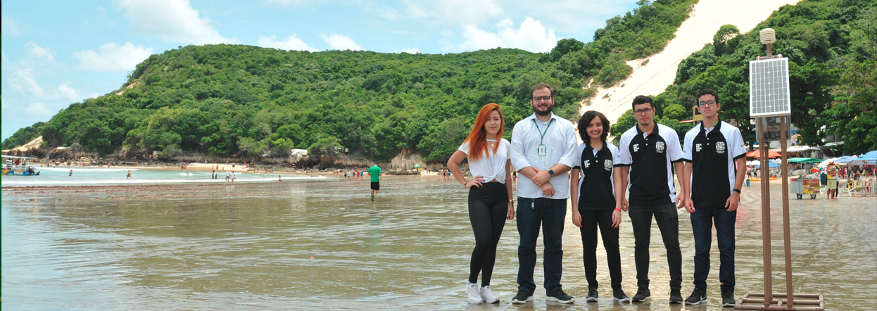 Grupo de alunos e Professor na Praia de Ponta Negra apresentando o projeto AirQ